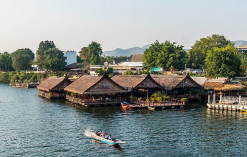 Longtail boat in front of floating houses