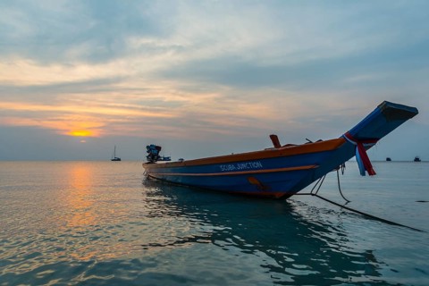 Longtail boat in the sea at sunset