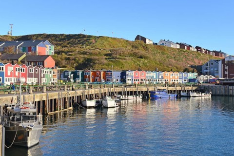 Inland harbor with boats and colorful lobster shacks