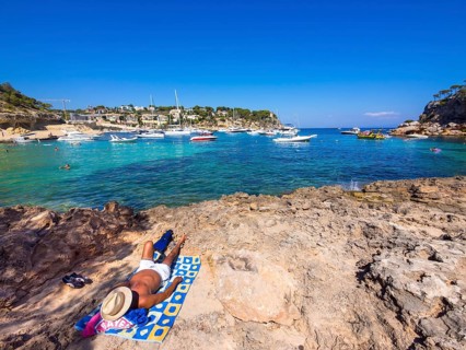 Holidaymaker lying at the bay of Portas Vells