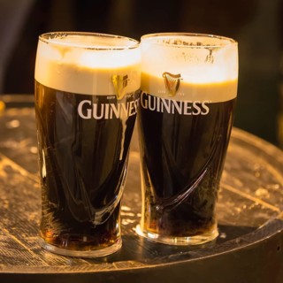 Beer glasses with Guinness beer on wooden barrel in the Irish Pub
