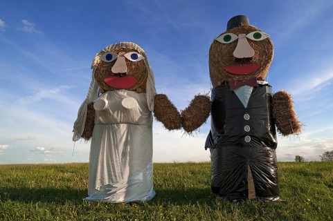 Wedding couple built of straw bales in a meadow
