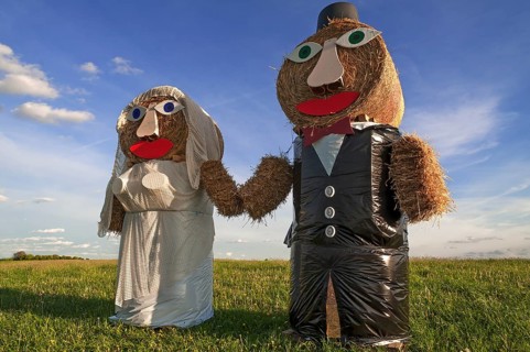 Wedding couple built of straw bales in a meadow