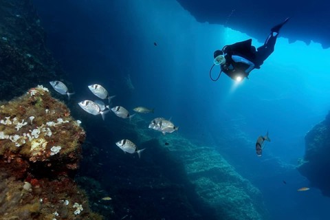 Diver in a cave with a lamp