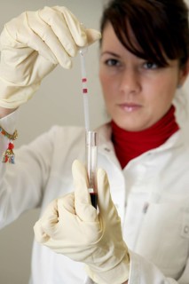 Female laboratory assistant in the laboratory holding a blood sample