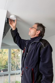 Caretaker with smoke detector in a stairwell
