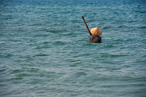 Mussel hunter wearing a straw hat