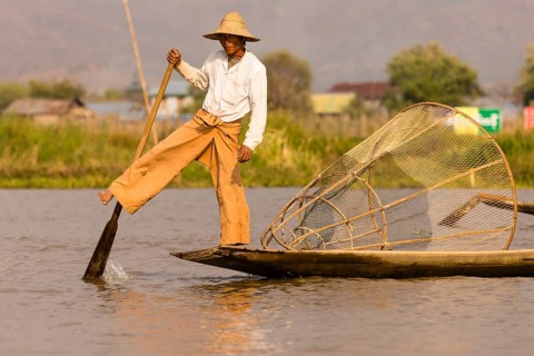 Fishermen rowing with one leg