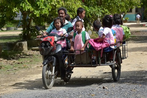 Old man with schoolchildren on a scooter