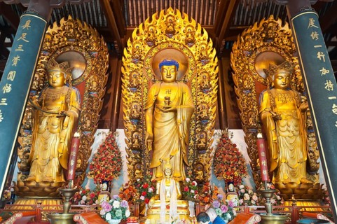 Three golden Buddhas with fire ring