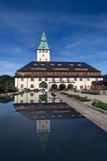 Schloss Elmau castle hotel with tower reflected in the fountain
