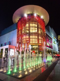 Siam Paragon shopping center at night with fountain in front of the illuminated glass facade
