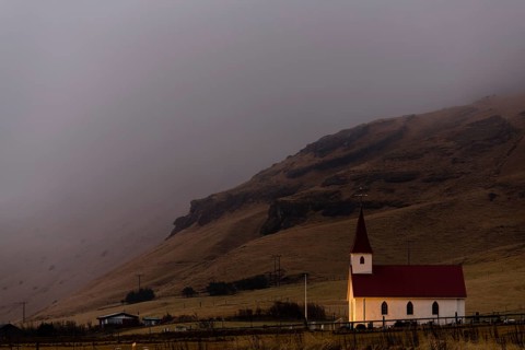Reyniskirkja church with fog-covered mountains