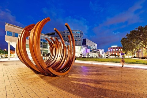 Modern sculpture of Bernar Venet with the inner city in the evening