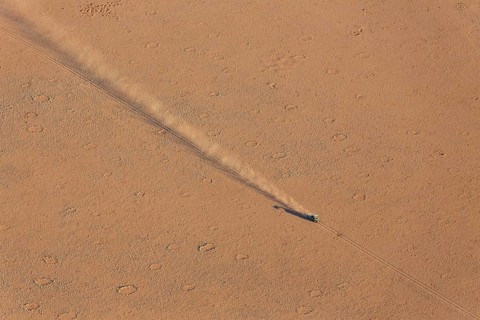A vehicle of the balloon ground crew crossing a sandy plain at the edge of the Namib Desert
