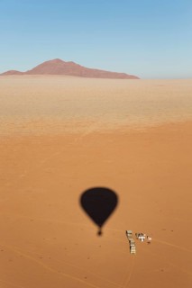 Shadow of a hot-air balloon at the intended landing spot in a true desert environment