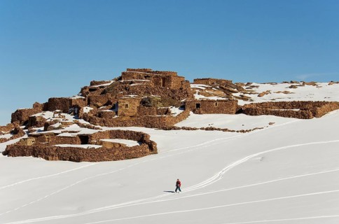 Snow covered Berber village and skier near to the Oukaimeden skiing centre in the High Atlas mountains