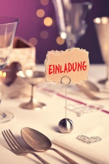 Note on festive table with the inscription Einladung or invitation