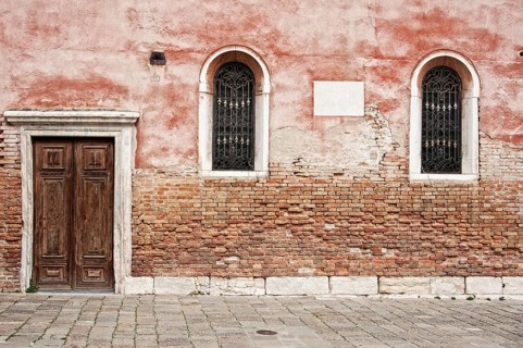 Red house wall with windows and doors in the San Polo district