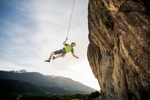 Climber hanging on the rope by the cliff