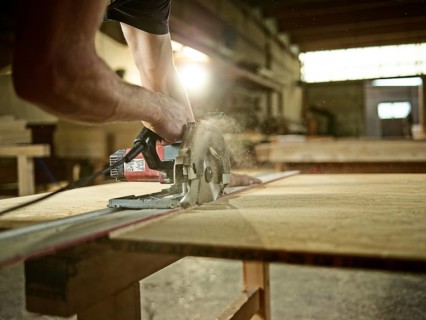 Carpenter cutting chipboard with a circular saw