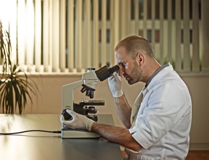 Doctor looking through microscope