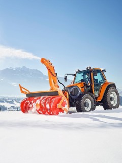 Tractor with a snow blower clearing snow