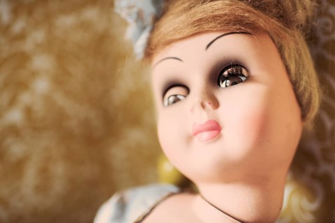 Face of an old fashioned doll looking away with a bored expression