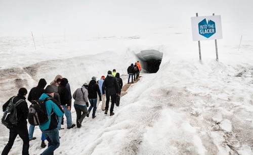 Tourists walking in to glacial cave