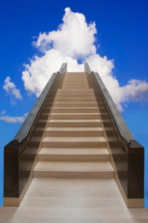 Long staircase leading up into the blue sky with white clouds
