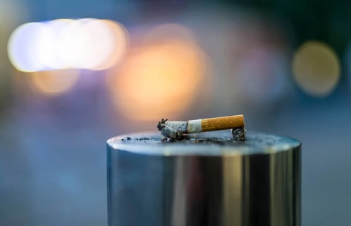 Discarded cigarette butt on metal post