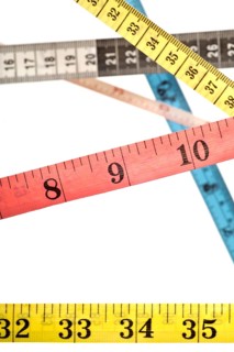 Various colourful tape measures criss-crossing over each other