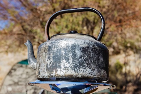 Heavily worn kettle on gas cooker