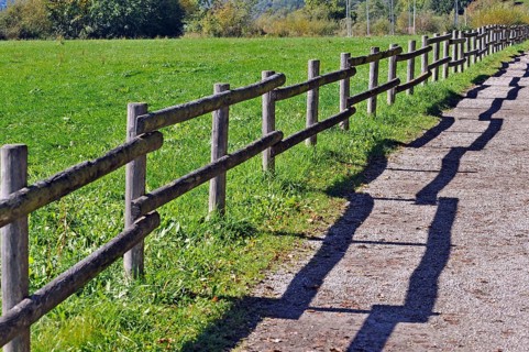Fence with a shadow along the promenade path