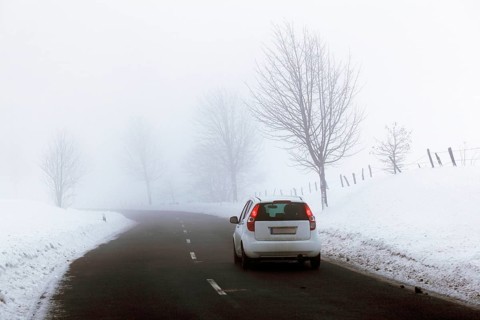 Car on a country road in a snow-covered landscape
