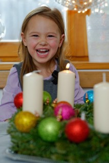 Girl enjoying the first lit candle on the Advent wreath