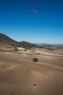 Paraglider above fields in the Sierra de Cadiz