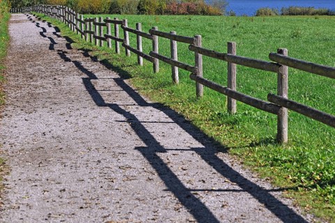 Fence with a shadow along the promenade path
