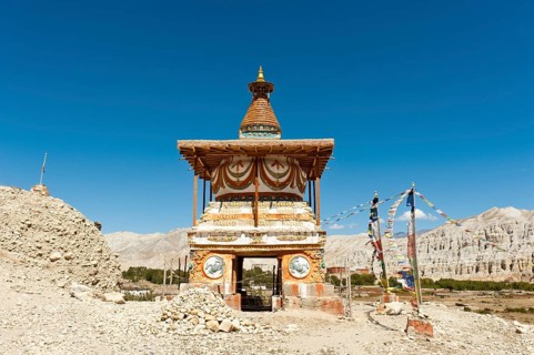 Colorful ornate Buddhist stupa at the entrance to the village