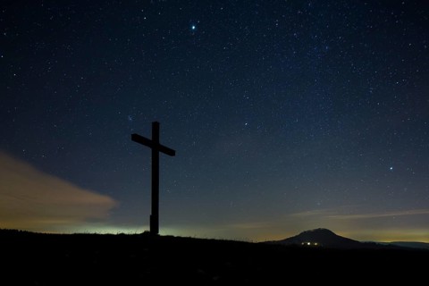 Summit cross on Bisberg Mountain with a starry sky