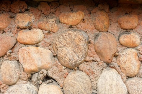 Mani stones with Tibetan inscriptions on wall