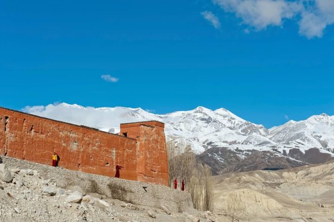 Red wall of a building with monks