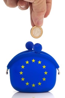 Hand dropping a euro coin in a blue purse with euro-stars