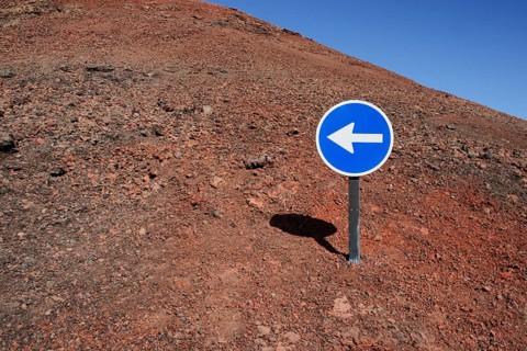 Blue sign with a white arrow pointing left