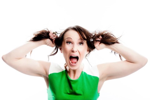 Screaming woman tearing at her own hair