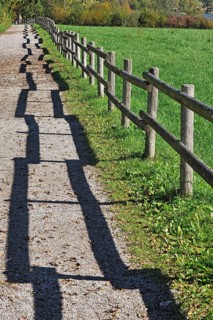 Fence with a shadow along the promenade path
