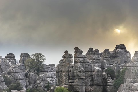 Bizarre limestone rock formations with the sun and fog