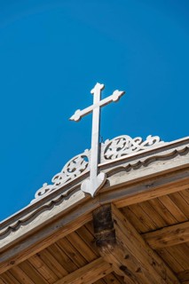 Crucifix on a wooden roof against a blue sky