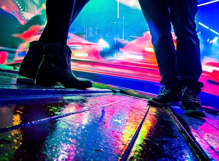 Legs of two people at a funfair