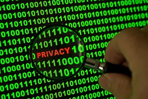Binary code with the word 'Privacy' viewed through a magnifying glass
